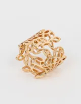 Anillo dorado con diseño floral calado y textura labrada.