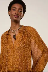 Camisa de mangas largas y amplias con estampado animal print, cierre de botones frontal y cuello padre con detalle fruncido.