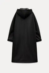 Parka larga negra con capucha ajustable con cordones, mangas largas con puños elásticos, bolsillos laterales y de plastrón en el pecho, bajo ajustable con cordón elástico y cierre frontal con cremallera metálica.