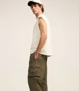 Pantalón paper touch color verde militar, con bolsillos laterales, cintura elástica y cordón de ajuste. Se convierte en bermuda gracias a un cierre a la altura de la rodilla.
