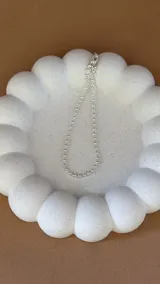 Pulsera plateada con cadena de bolitas.