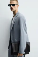 Blazer celeste de corte slim fit, con solapas de muesca, manga larga con botones en los puños, bolsillo de vivo en el pecho, bolsillos de solapa en la cadera, bolsillo interior, aberturas en la espalda y cierre frontal con botones.