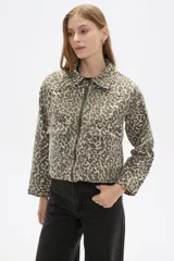 Chaqueta corta de jean con estampado animal print en tonos beige y gris, cuello camisero, cierre frontal con cremallera, bolsillos de parche en el pecho y corte entallado.