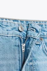 Minifalda de jean celeste con tiro medio, trabillas, cinco bolsillos y cierre frontal con cremallera y botón metálico.