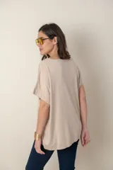 Remera holgada color beige, de escote en V y mangas cortas.