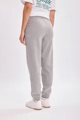 Pantalón deportivo jogger gris claro con cintura elástica ajustable con cordón y tobillos ajustados.