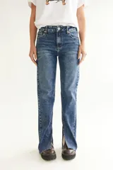 Pantalón de jean azul con efecto lavado, corte recto y tajo en la pierna.
