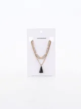 Collar doble dorado con cadena de eslabones grandes y cadena fina con dije colgante triangular negro.