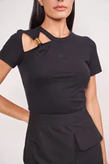 Blusa negra de mangas cortas con cuello redondo y corte en el hombro con detalle de aro dorado.