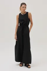 Mono negro de lino con corte palazzo, cintura elastizada con cordón ajustable y sin mangas.