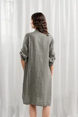 Túnica blanca de lino, corte holgado, con cuello mao, cierre frontal con botones y mangas largas con trabillas para enrollar.