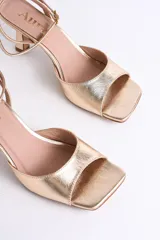 Sandalia plateada de fiesta con diseño elegante y minimalista. Presenta punta cuadrada, tira delantera ancha y pulsera al tobillo con hebilla regulable, que brinda firmeza y comodidad.