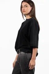 Remera blanca de mangas cortas con cuello redondo y ruedo con efecto tie-dye en color violeta.