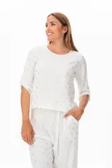 Blusa blanca con estampado de hojas doradas, de corte holgado y mangas 3/4 con trabillas.