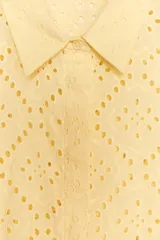 Camisa amarilla de cuello solapa y manga larga acabada en puño. Detalle de bordados perforados a tono. Cierre frontal con botones ocultos por solapa.