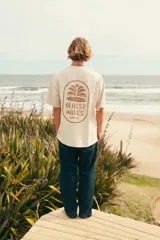 Remerón color crudo con estampa marrón en la espalda con el texto "Glassy Waves Surf Co.".