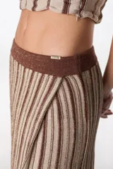 Falda midi tejida a rayas verticales en tonos celeste y azul, con cintura elástica y abertura lateral.