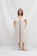 Vestido midi azul de lino con escote en V, mangas cortas con volados, bolsillos laterales y corte amplio. Presenta cintas verticales a contratono en el frente.