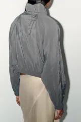 Chaqueta gris confeccionada en hilatura con mezcla de modal, de manga larga con puños elásticos, bolsillos laterales, bajo con elástico y cierre frontal con cremallera metálica.