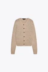Chaqueta color beige de punto con cuello redondo, manga larga, rib en los bordes y cierre frontal con botones negros.