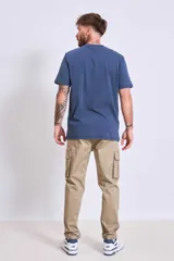 Pantalón cargo color beige, de corte recto, con bolsillos laterales con fuelle y cierre de solapa.