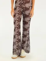 Pantalón flare de malla transparente color marrón con estampado de tigres blancos.
