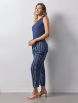 Pantalón capri de algodón estampado a rayas verticales en tonos celeste, rosa y beige. Tiene pretina elastizada, bolsillos delanteros y tajos laterales con botones.