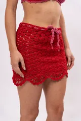 Minifalda tejida a crochet color rojo con cordón de ajuste rosa en la cintura.