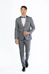 Traje de hombre de dos piezas color azul vibrante, compuesto por saco de un solo botón con solapas de pico en negro y pantalón a juego. Se complementa con camisa blanca, moño azul y pañuelo de bolsillo negro.