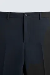 Pantalón de vestir color verde oliva, corte slim fit, con bolsillos laterales y traseros de ojal con botón. Cierre frontal con cremallera y botón.