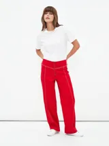 Pantalón rojo de corte recto con cierre frontal y costuras a la vista.
