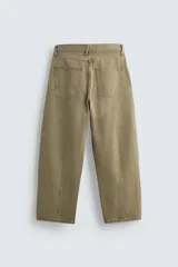 Pantalón de jean color verde oliva, corte balloon fit, con cinco bolsillos, efecto lavado y costuras giradas hacia adelante.