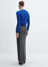 Cárdigan color crema de tejido de punto fino, corte recto, cuello redondo, manga larga, cierre frontal con botones y terminaciones en canalé.