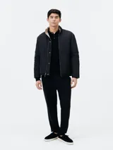 Campera acolchada reversible, color negro con interior beige, cuello mao y cierre frontal con cremallera.