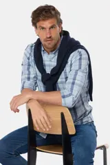 Camisa de hombre a cuadros en tonos celeste y azul, de manga larga, corte regular y logo bordado en el pecho.