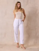 Pantalón largo de lino y rayón a rayas verticales grises y blancas. Tiene pretina elastizada con lazo de ajuste, bolsillos delanteros y traseros.