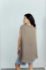 Blusa color crudo de lino, sin mangas, con corte acinturado y cuello amplio.