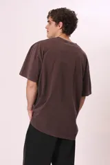 Camiseta de manga corta, color gris oscuro con efecto lavado, corte oversize y cuello redondo. Presenta texto estampado en blanco en el pecho que dice "CREW MEMBER".