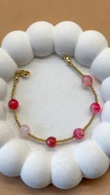 Pulsera con hilo de acero dorado y cuentas de ágata rosa y roja.