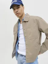 Campera de denim color beige, con cuello amplio, puños con botones y cierre frontal con botones. Incluye bolsillos en el pecho y laterales. Tejido denim de sarga resistente y con protección contra el viento.