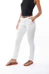 Pantalón blanco de corte recto, con bolsillos laterales y traseros. Se ajusta a la cintura con cinturón de cuero marrón.