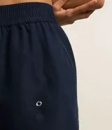 Bermuda deportiva corta de microfibra ligera, color lila, con cintura elástica funcional y textura de agueros.