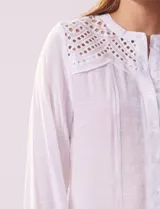 Blusa azul marino de manga larga con cuello redondo con detalle de broderie y cierre frontal con botones.