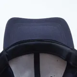 Gorra de béisbol azul marino con visera curva y botón superior.
