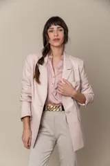 Blazer de cuero color lavanda, con cuello y solapa, y dos bolsillos frontales.