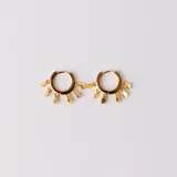 Aros dorados tipo argolla con pequeños dijes colgantes en forma de lágrima. Fabricados en plata 925 con baño de oro.