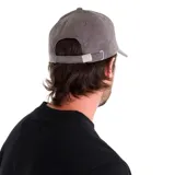 Gorra de pana color mostaza con visera curva, seis paneles y logo de Caterpillar bordado en negro en el frente.