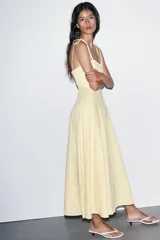 Vestido midi amarillo claro, con escote corazón con volantes y tirantes finos ajustables con lazo. Falda acampanada con forro interior.