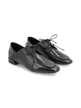 Zapato de cuero negro con cordones, estilo Oxford, con puntera reptil y suela laqueada.