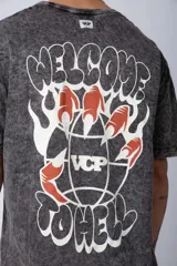 Remera gris con efecto acid wash, corte holgado y estampa frontal con una mano sosteniendo el mundo VCP.